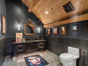 Bathroom featuring a wainscoted wall, vanity, light marble finish flooring, a vaulted wood ceiling, and recessed lighting