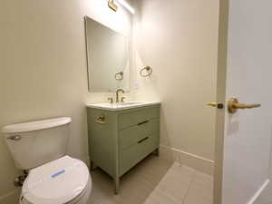 Half bath with vanity and light tile patterned flooring