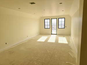 Unfurnished room with vaulted ceiling and light flooring
