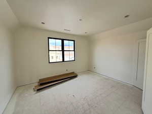 Unfurnished room with lofted ceiling