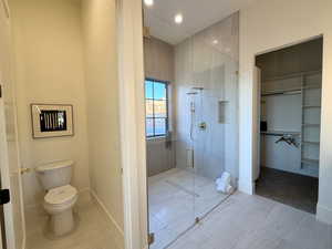 Bathroom featuring a shower stall, a walk in closet, and recessed lighting