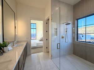 Ensuite bathroom featuring a stall shower and double vanity