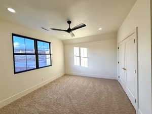 Unfurnished bedroom with a closet, lofted ceiling, a ceiling fan, recessed lighting, and carpet