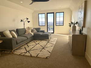 Living area with lofted ceiling, light colored carpet, recessed lighting, and ceiling fan