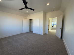 Unfurnished bedroom with dark colored carpet, ceiling fan, a closet, recessed lighting, and vaulted ceiling