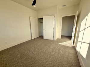 Unfurnished bedroom with a closet, light carpet, and ceiling fan