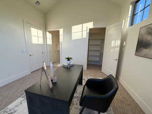Carpeted office space featuring lofted ceiling