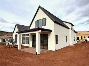 Rear view of house featuring a patio area and stucco siding