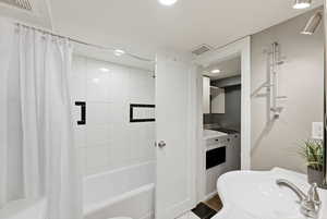 Full bathroom featuring shower / bath combo with shower curtain, washing machine and dryer, recessed lighting, and vanity