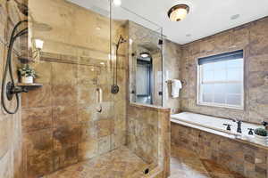 Full bathroom featuring a garden tub and a shower stall