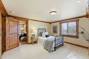Bedroom featuring ornamental molding and light carpet