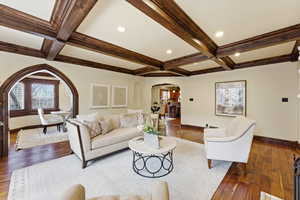 Living area featuring arched walkways, coffered ceiling, wood-type flooring, and recessed lighting