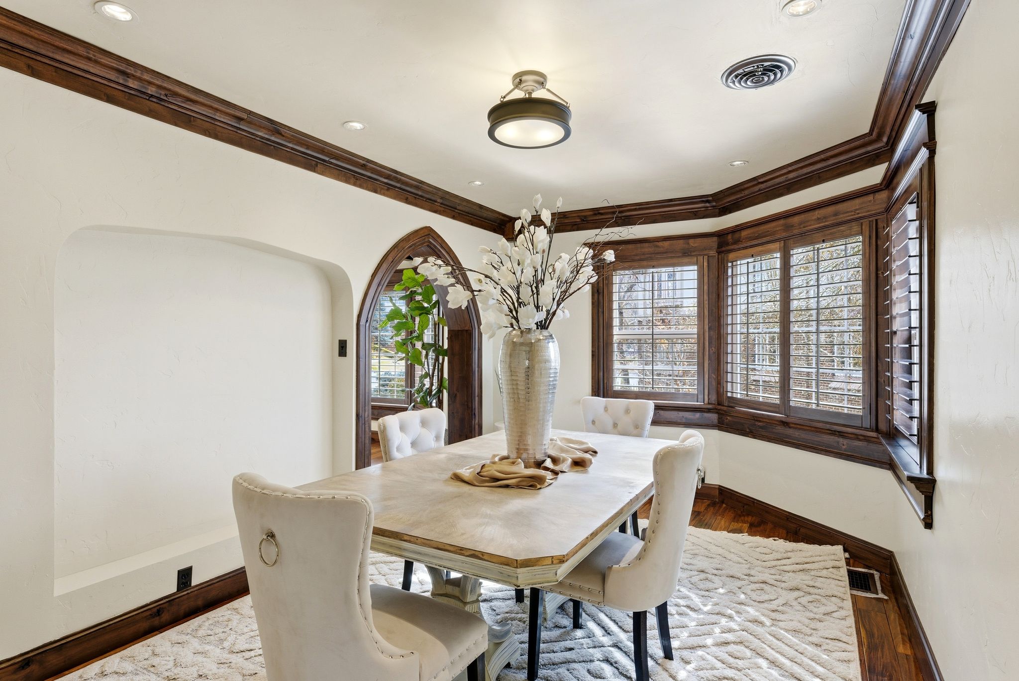 Dining room with wood finished floors, plenty of natural light, and ornamental molding