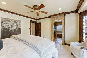 Bedroom featuring crown molding, ceiling fan, arched walkways, connected bathroom, and recessed lighting