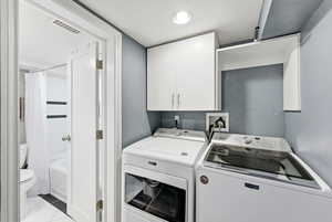 Laundry room featuring washing machine and clothes dryer and cabinet space
