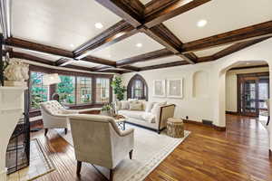 Living room featuring arched walkways, hardwood / wood-style floors, coffered ceiling, and recessed lighting