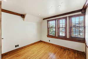 Spare room featuring light wood-type flooring, lofted ceiling, and recessed lighting