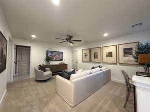 Living area with ceiling fan, light carpet, and recessed lighting