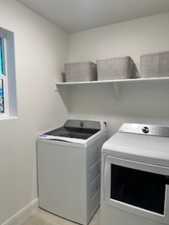 Laundry area featuring baseboards and separate washer and dryer