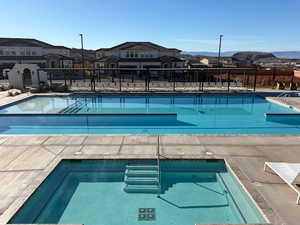 Community pool with a patio area and a residential view