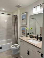 Full bath featuring shower / tub combo, vanity, and light tile patterned floors