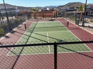 View of tennis court with a residential view