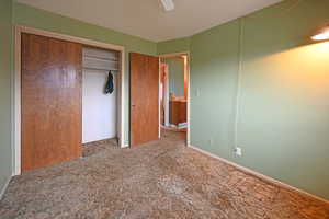 Unfurnished bedroom featuring a closet, a textured ceiling, ceiling fan, and carpet floors