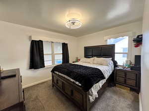 Bedroom with baseboards and dark carpet