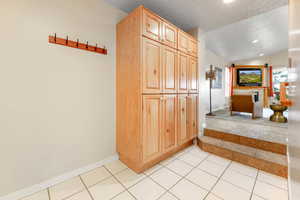 Hallway with light tile patterned floors and recessed lighting