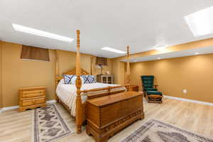 Bedroom with a textured ceiling and light wood finished floors