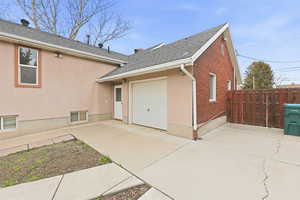 View of side of home featuring roof with shingles, an attached garage, concrete driveway, and brick siding