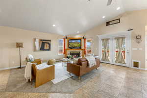 Living area with recessed lighting, vaulted ceiling, ceiling fan, and a tiled fireplace