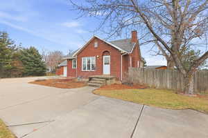 Bungalow-style home with brick siding, a chimney, and a shingled roof