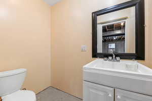 Half bathroom with concrete floors and vanity