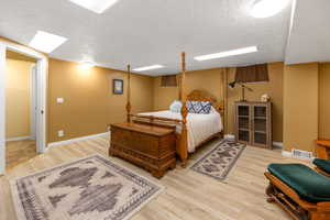 Bedroom featuring light wood-type flooring and a textured ceiling