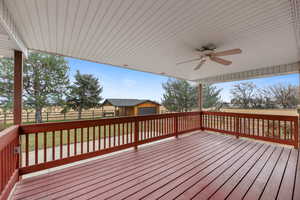 Deck featuring an outbuilding and ceiling fan