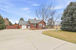 Ranch-style home featuring brick siding, driveway, a chimney, a garage, and roof with shingles
