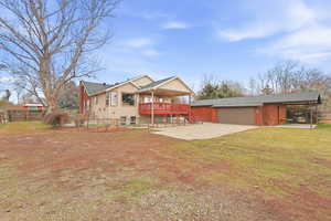View of front of property featuring a wooden deck, concrete driveway, and a patio