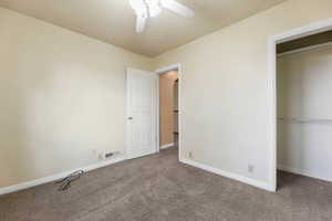 Unfurnished bedroom with carpet flooring, a textured ceiling, a closet, and ceiling fan