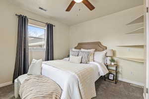 Bedroom featuring a textured ceiling, carpet floors, and ceiling fan