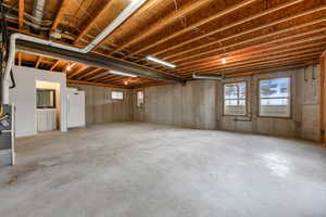 Basement with freestanding refrigerator and healthy amount of natural light