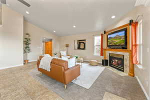 Bedroom with a tiled fireplace, lofted ceiling, and recessed lighting