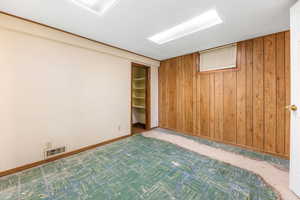 Finished basement featuring wood walls and baseboards