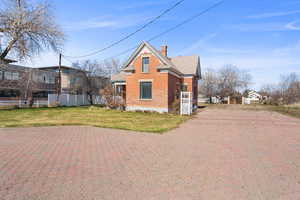 View of side of property with brick paver driveway