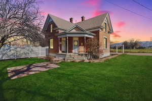 View of front facade with covered porch, brick siding, a chimney, and a shingled roof in a digitally enhanced photo to show potential.