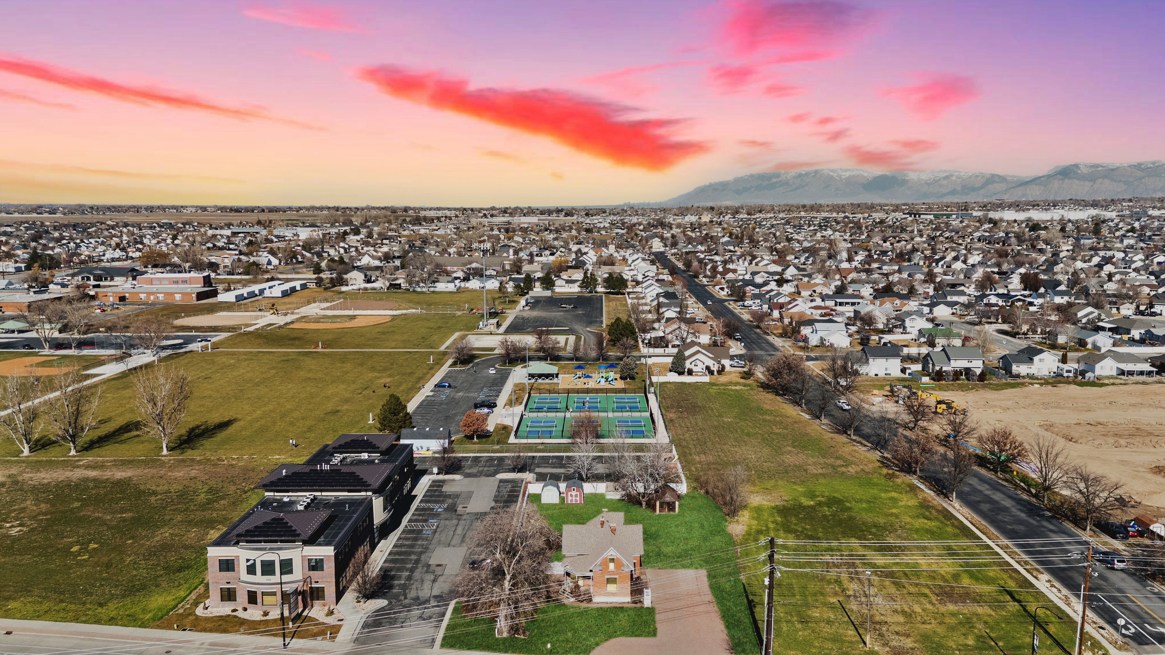Aerial perspective of suburban area featuring a mountainous background, digitally enhanced