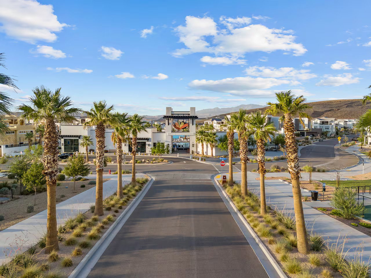 View of asphalt road featuring traffic signs, sidewalks, and a mountain view