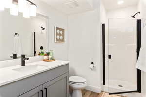 Bathroom with vanity, a shower stall, and light wood finished floors