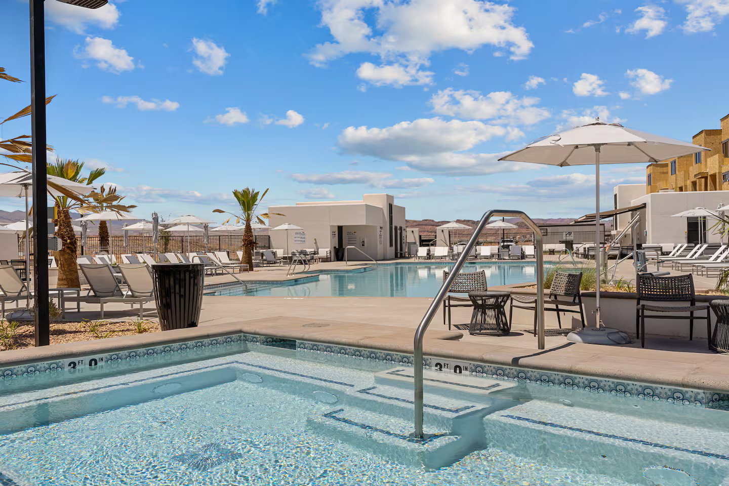 Community pool with a patio area and a community hot tub