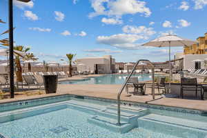 Community pool with a patio area and a community hot tub